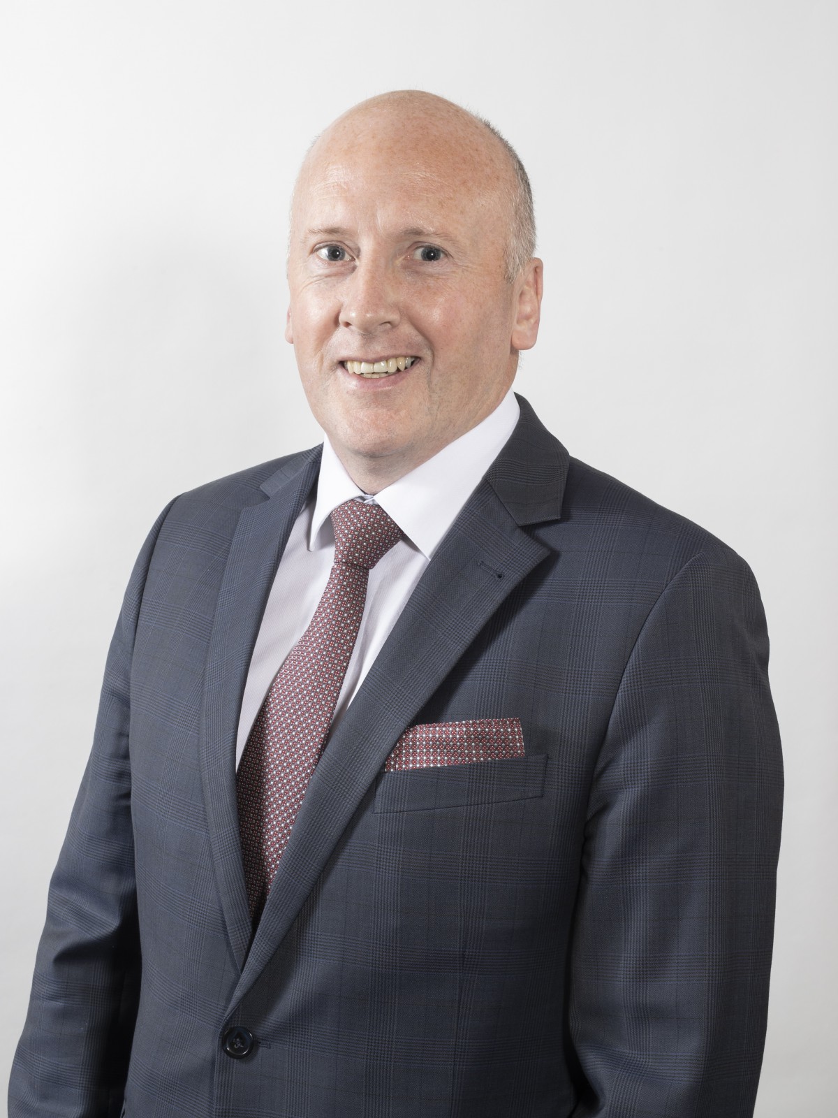 Gentleman with grey suit, white shirt and burgundy and white tie